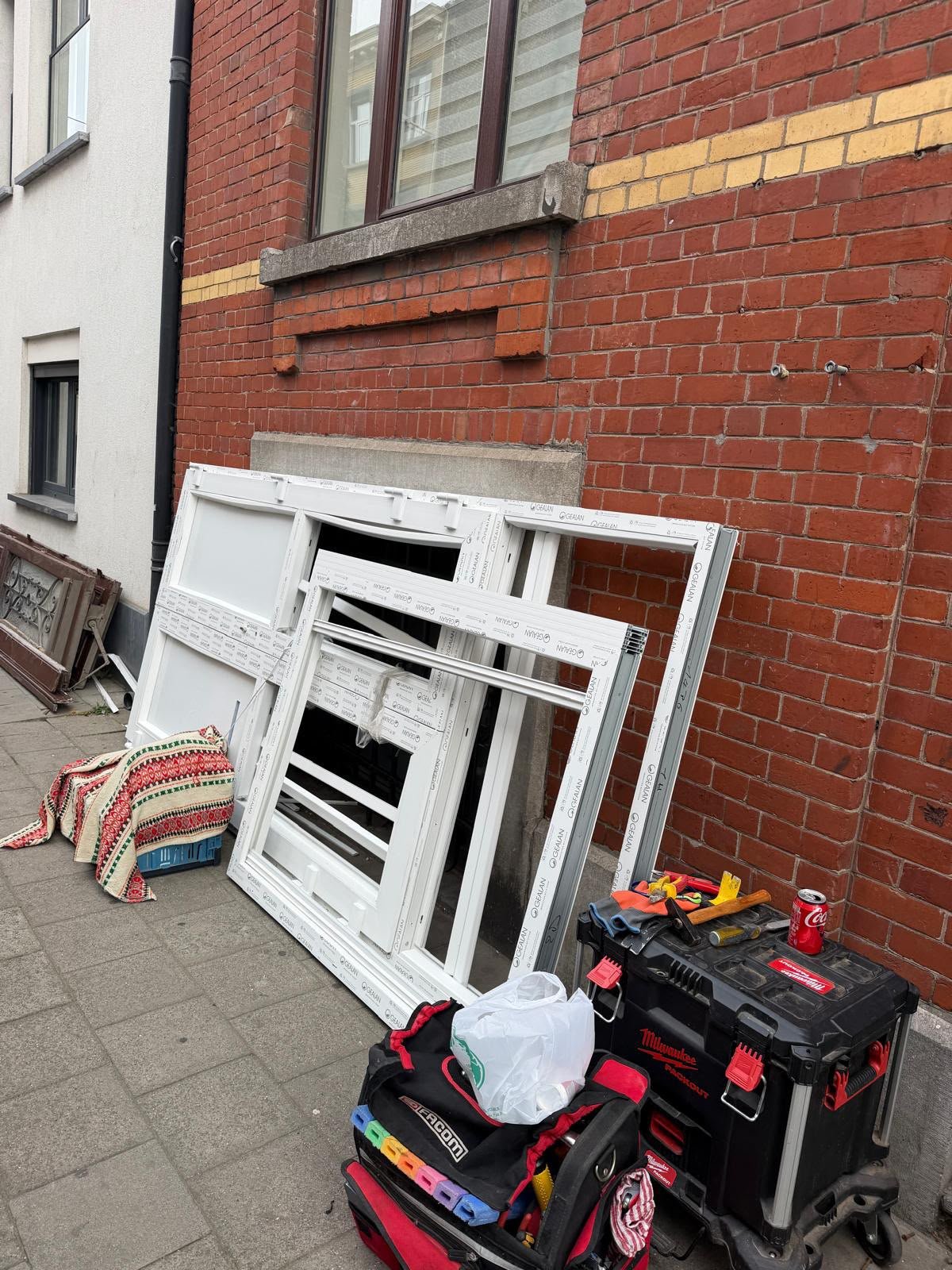 Caisse à outils de serrurier et châssis blancs contre un mur en briques