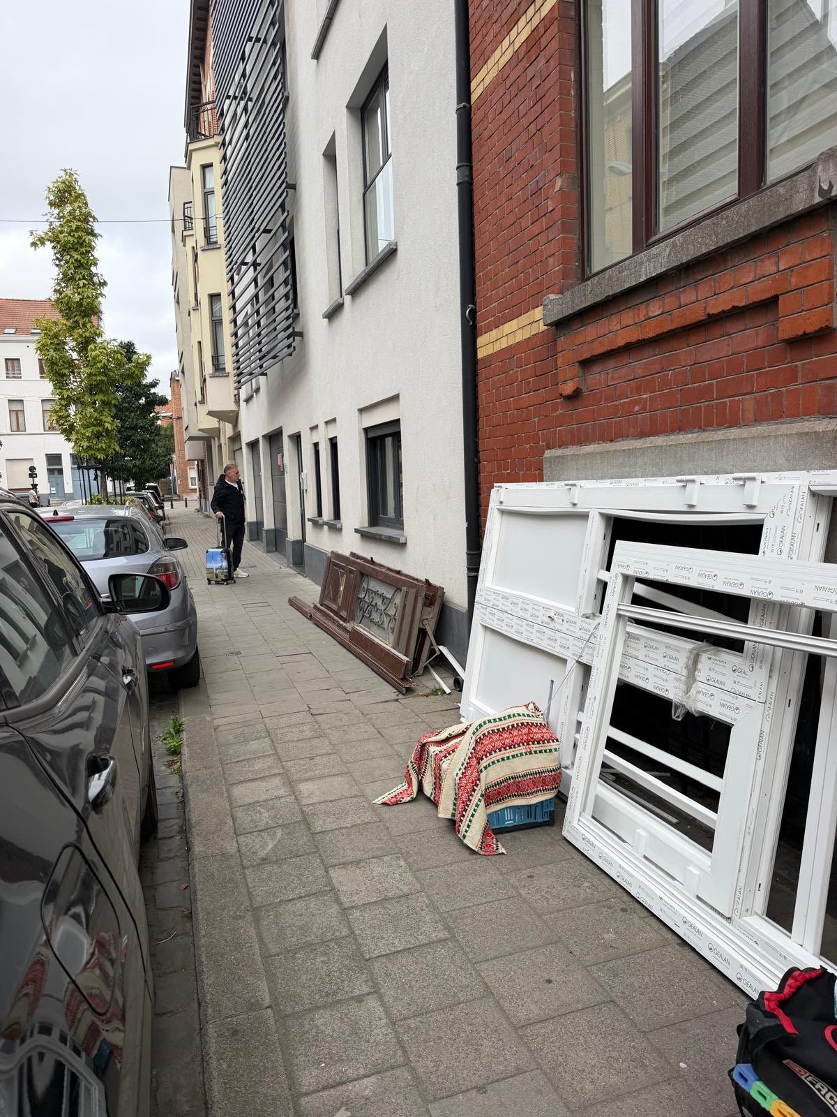 Rue de quartier avec anciens châssis déposés pendant un chantier de porte d'entrée